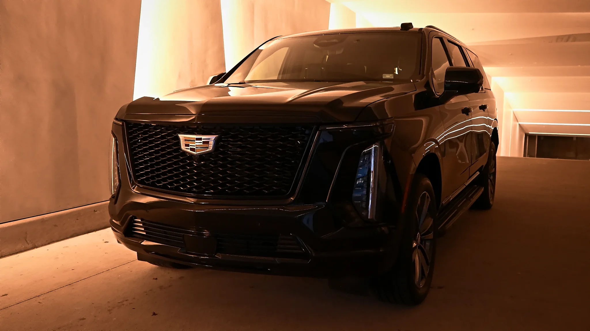 Cadillac Escalade ESV under amber light in a covered drive