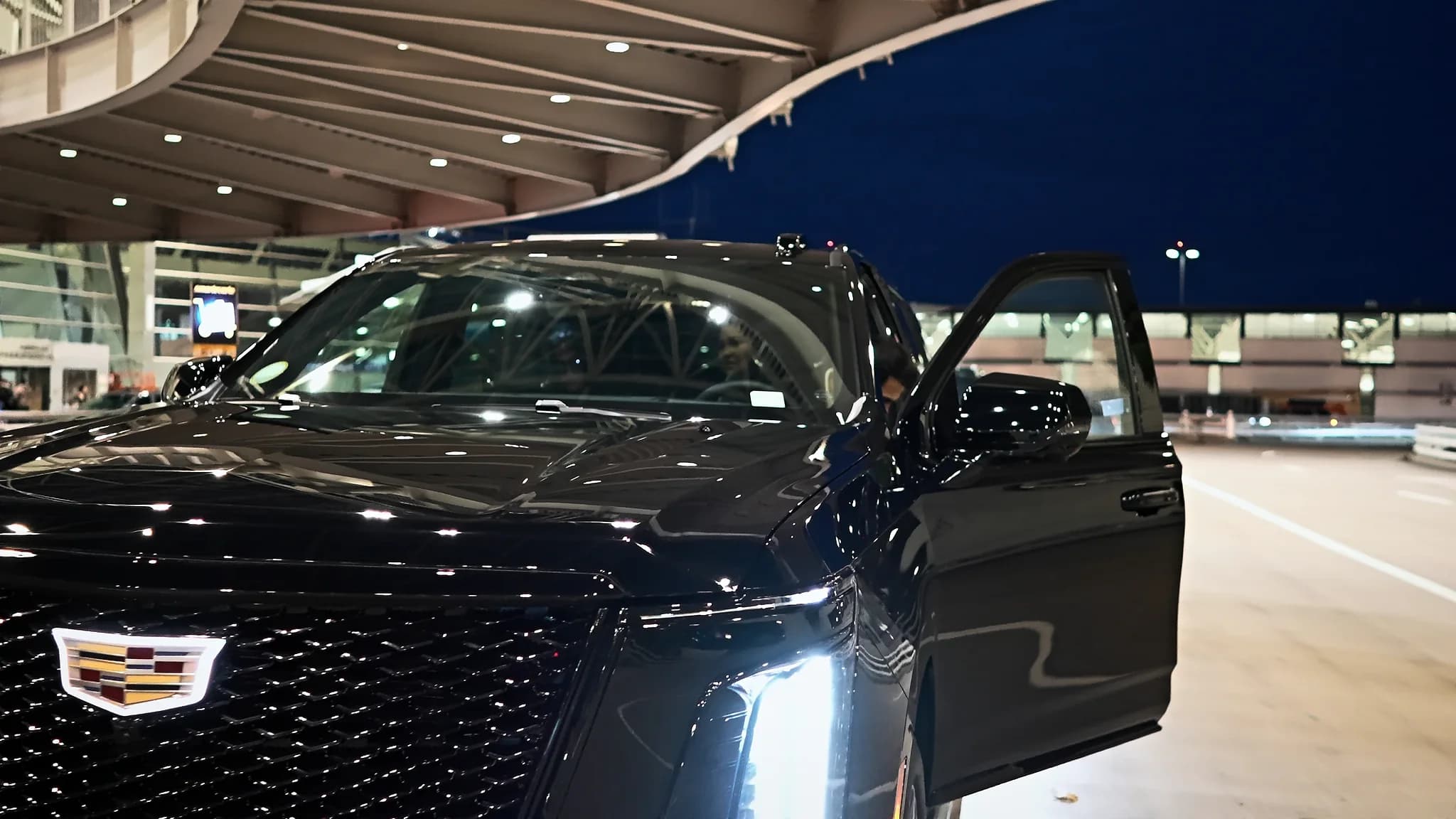 Cadillac Escalade ESV at the Portland International terminal curb at night