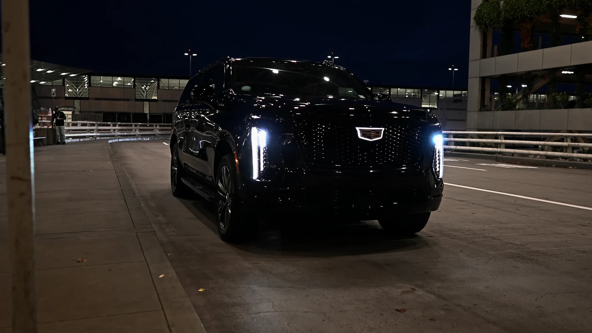 Cadillac Escalade ESV at the Portland International terminal at night, headlights on
