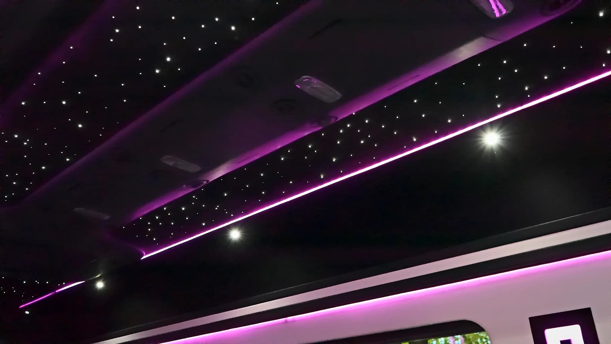 Fibre-optic starlight ceiling in the Sprinter Jet Limousine under violet light