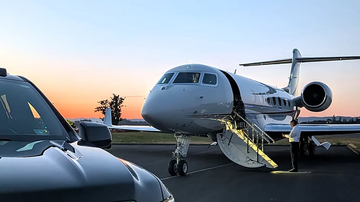 Cadillac Escalade beside a private jet at sunset — planeside FBO chauffeur pickup