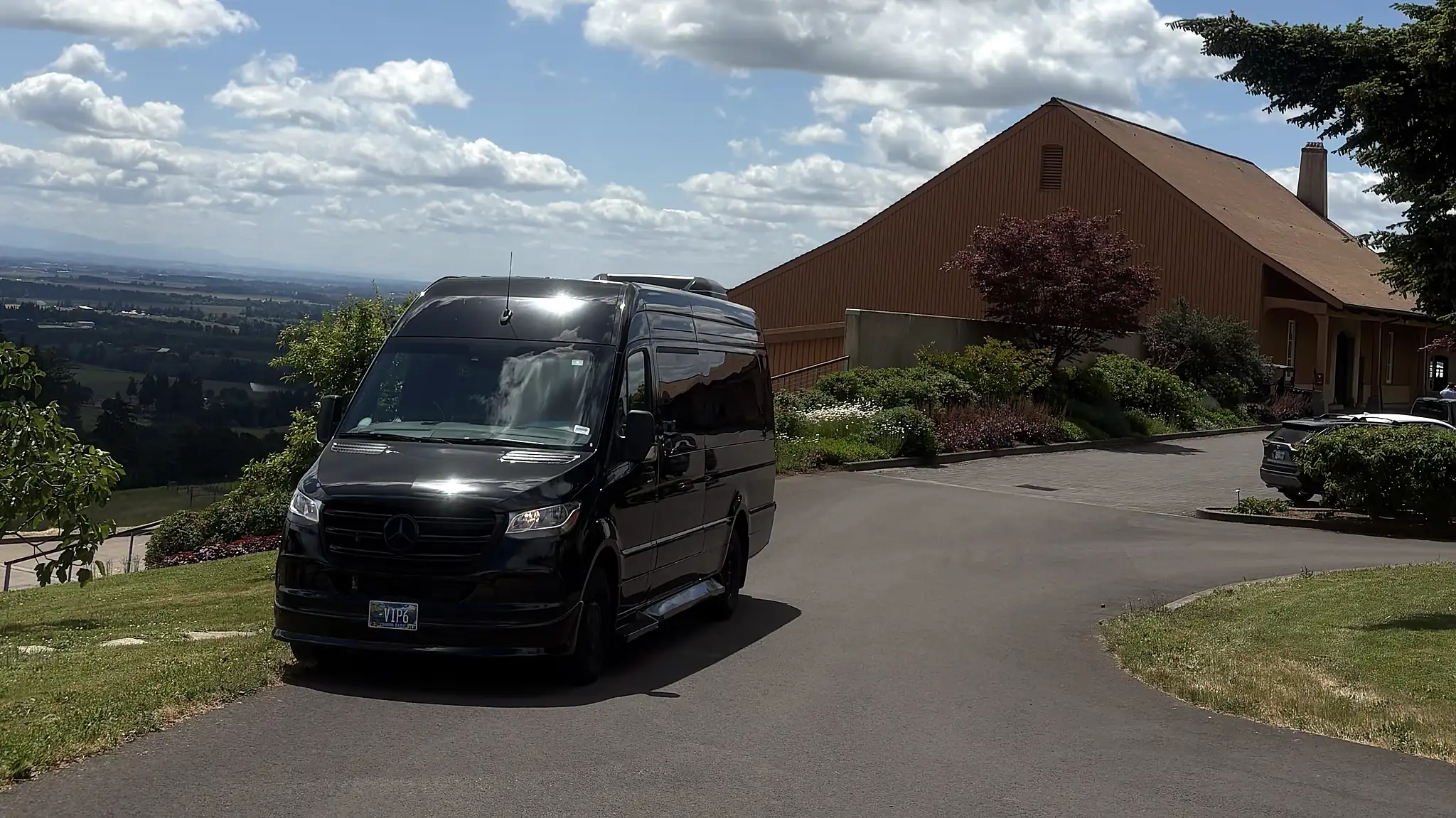 Mercedes-Benz Sprinter on a hillside winery driveway with valley view — full-day wine tour in progress