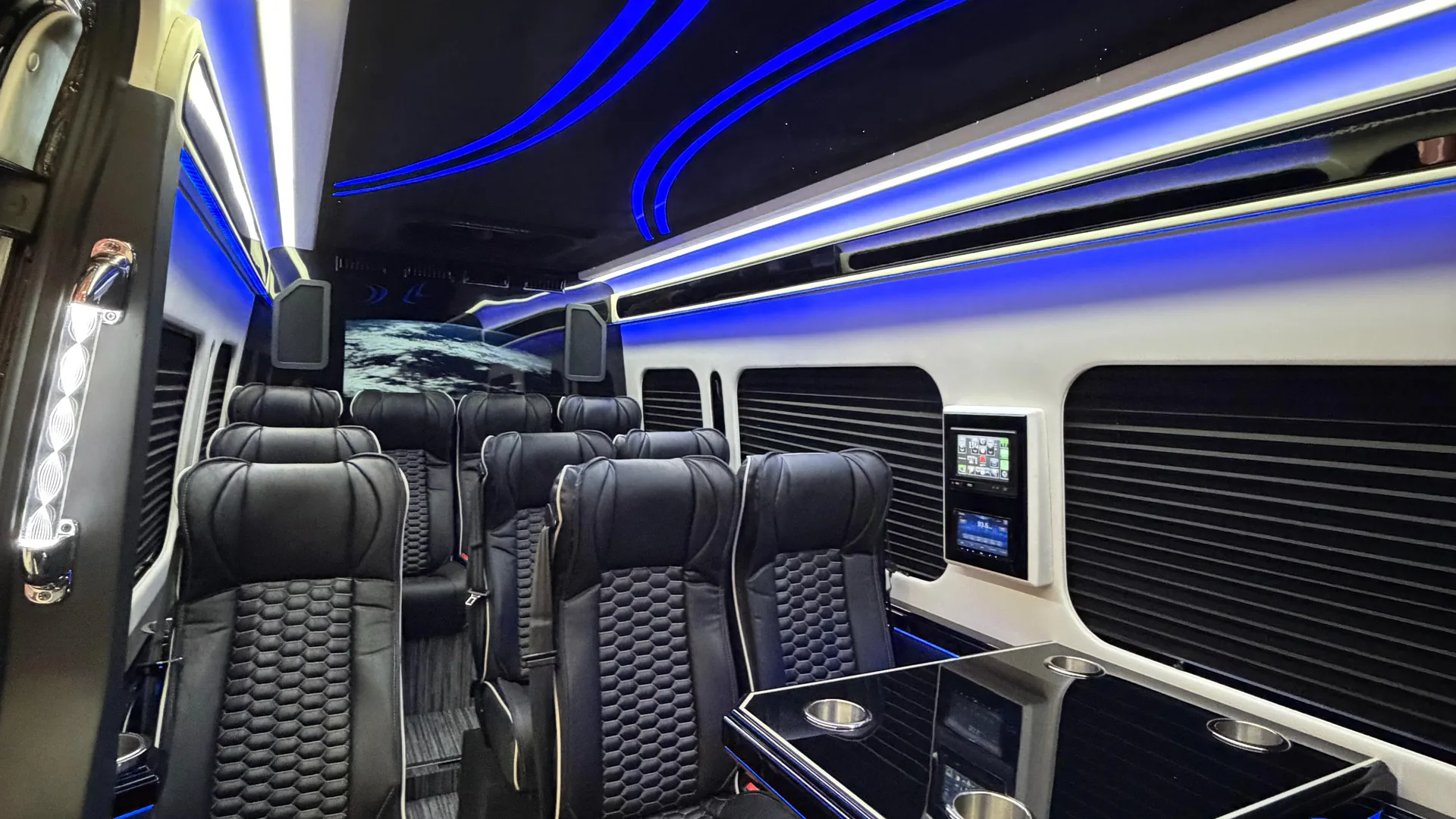 Portland Executive Limo cabin: starlight headliner, blue LED channels, quilted leather captain chairs, window shades, and the lounge table in the Marquee Chauffeur Sprinter 3500
