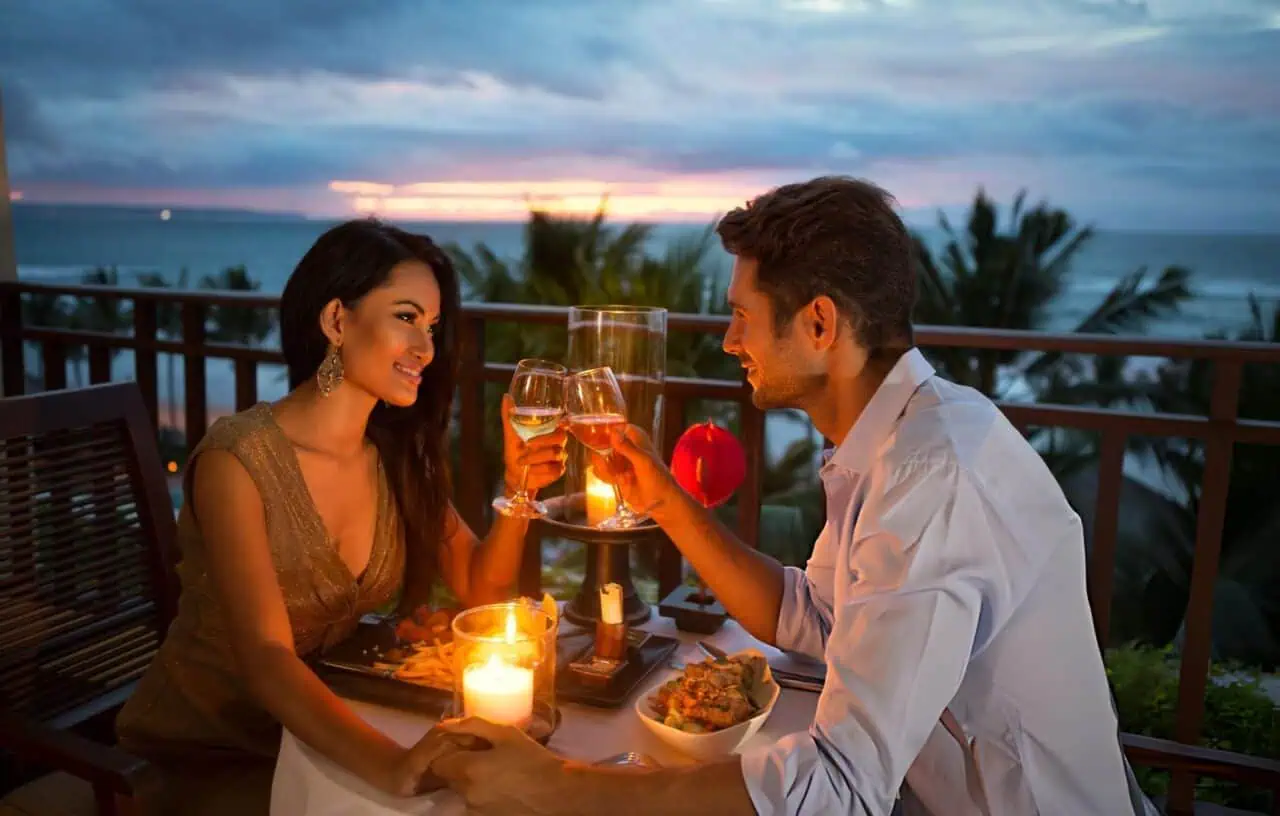 Night-Out Groups & Celebrations A couple toasting over a candlelit dinner, illustrating anniversary and date-night chauffeur service in Portland